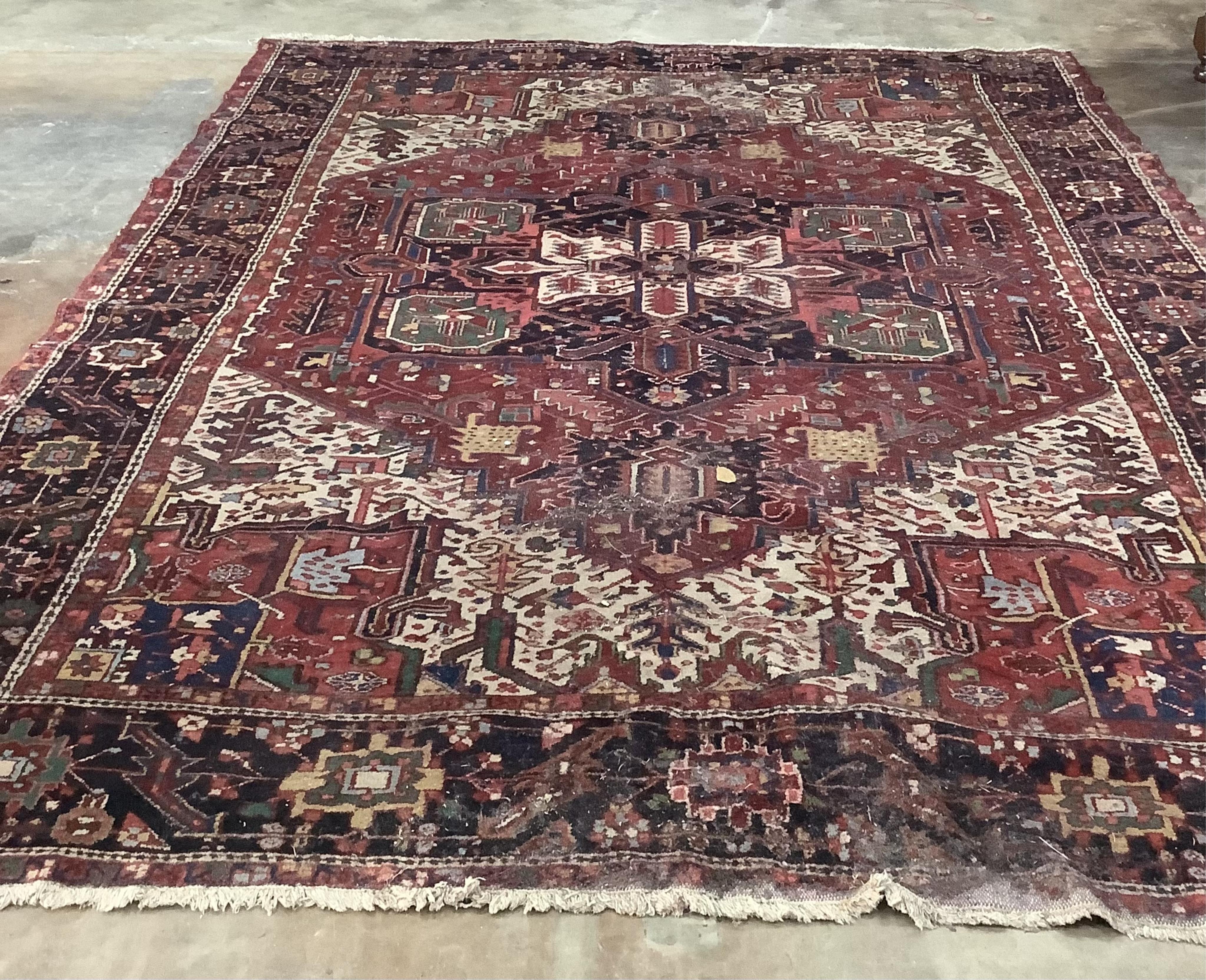 A Heriz red ground carpet, 340 x 267cm. Condition - poor to fair